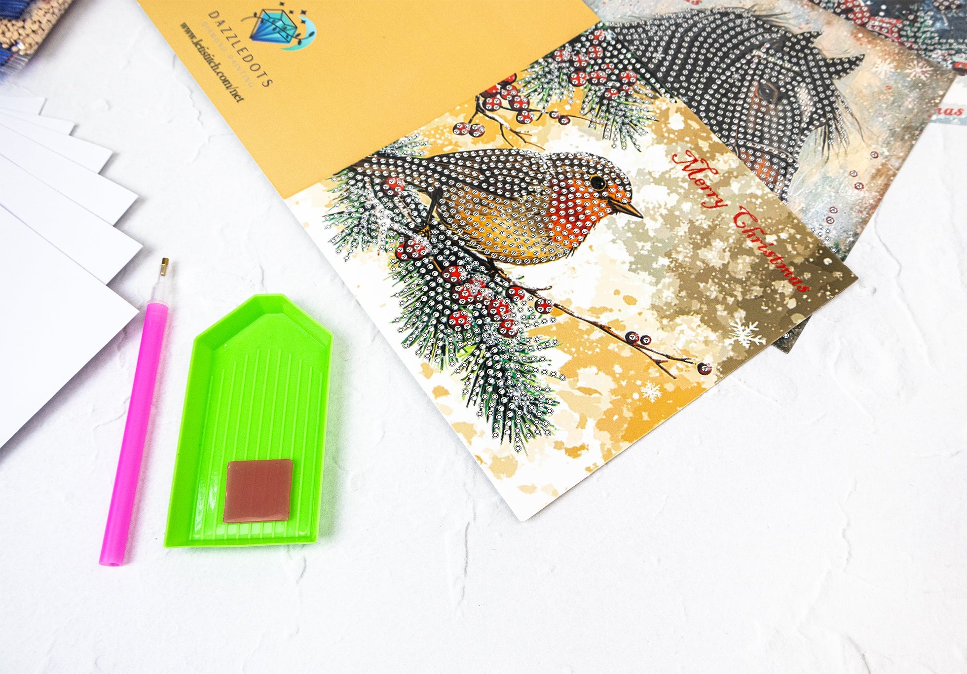Decorative greeting card with a bird design on a white surface with stationery items.