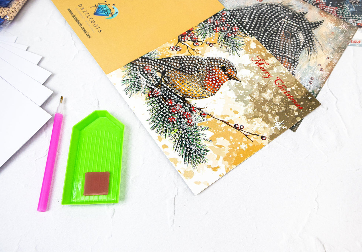 Decorative greeting card with a bird design on a white surface with stationery items.