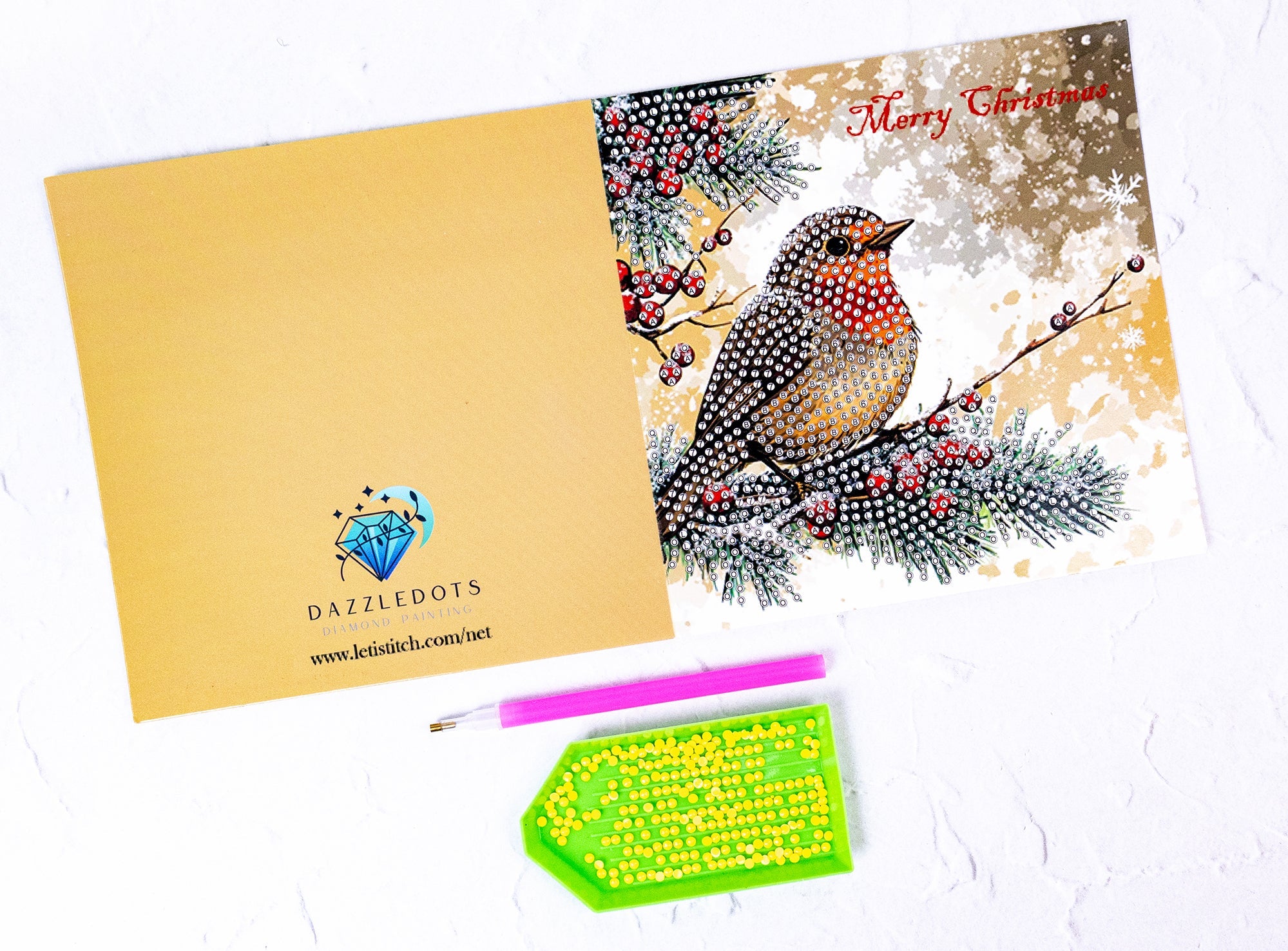 Christmas card with a bird design, envelope, and craft supplies on a white background