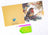 Christmas card with a bird design, envelope, and craft supplies on a white background