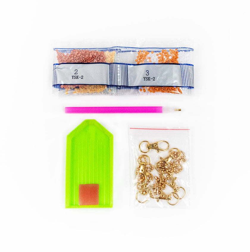 Assorted fishing tackle items including a green tag, pink tool, and gold hooks on a white background.