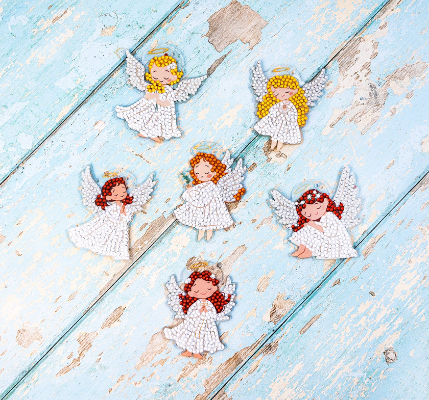 Decorative angel figurines on a light blue wooden surface