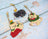 Four cat-shaped keychains with festive designs on a rustic wooden surface.