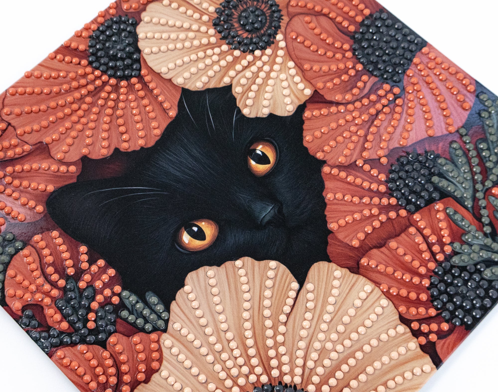 crystal art Black cat with orange eyes peeking out from a textured floral and shell pattern
