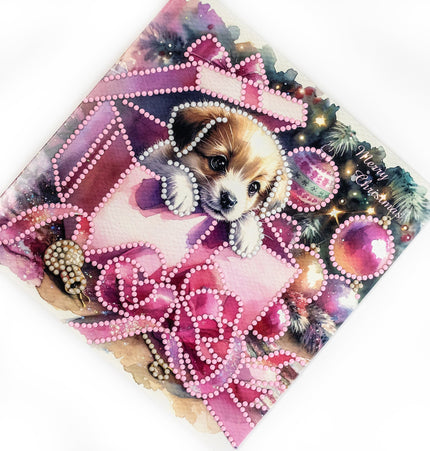 Christmas card with a puppy surrounded by pink decorations and ornaments.