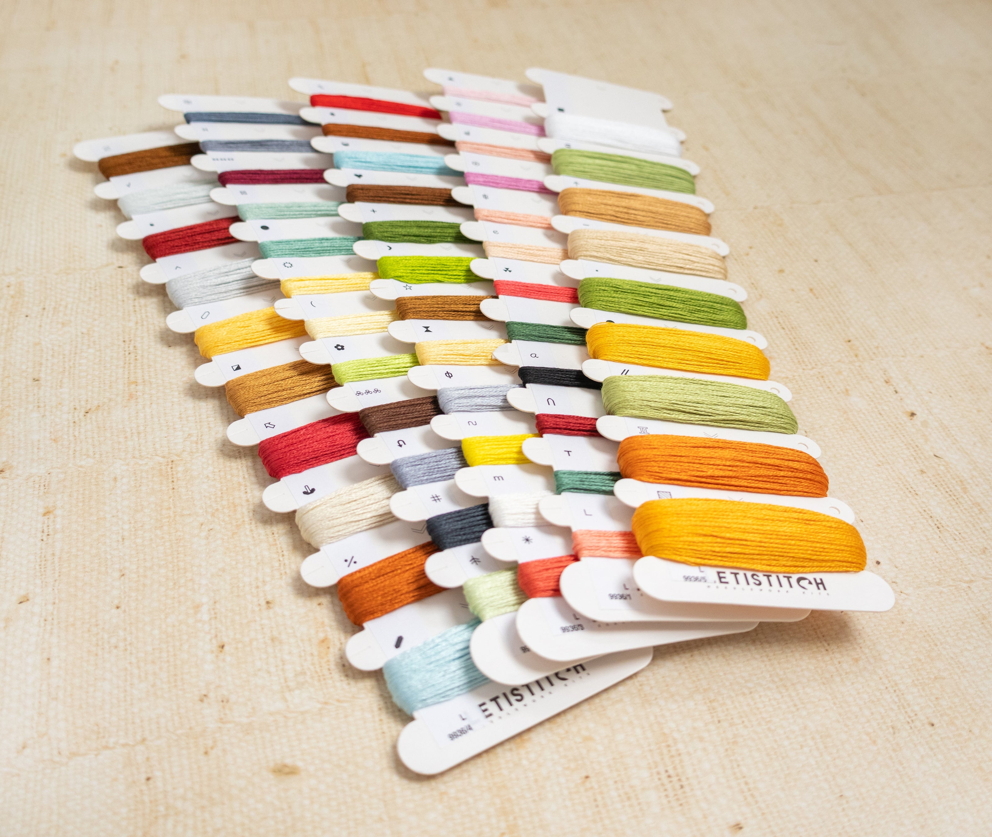 Set of colorful embroidery floss on wooden sticks with 'ETISILK' branding.
