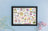 Framed spring-themed artwork with illustrations on a light blue background