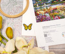 Cross-stitch kit with a deer and floral design, surrounded by flowers and a butterfly.