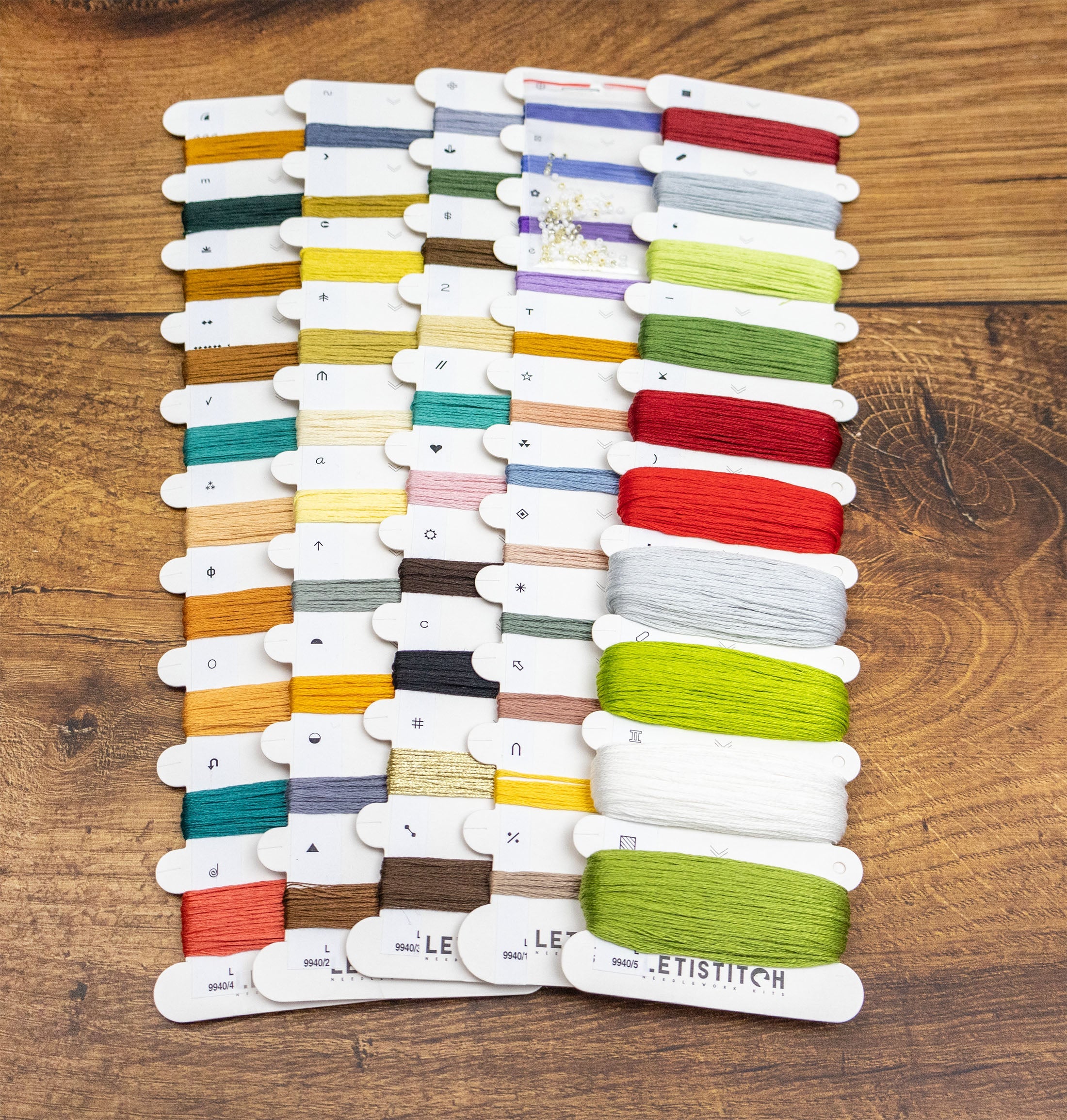 Color swatch card with various threads on a wooden surface