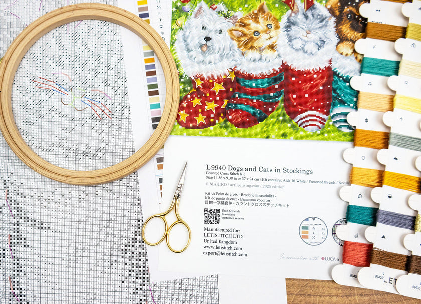 Embroidery kit with cross-stitch pattern, threads, scissors, and a printed design of dogs and cats in stockings.