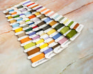 Color swatch card with embroidery threads on a marble surface