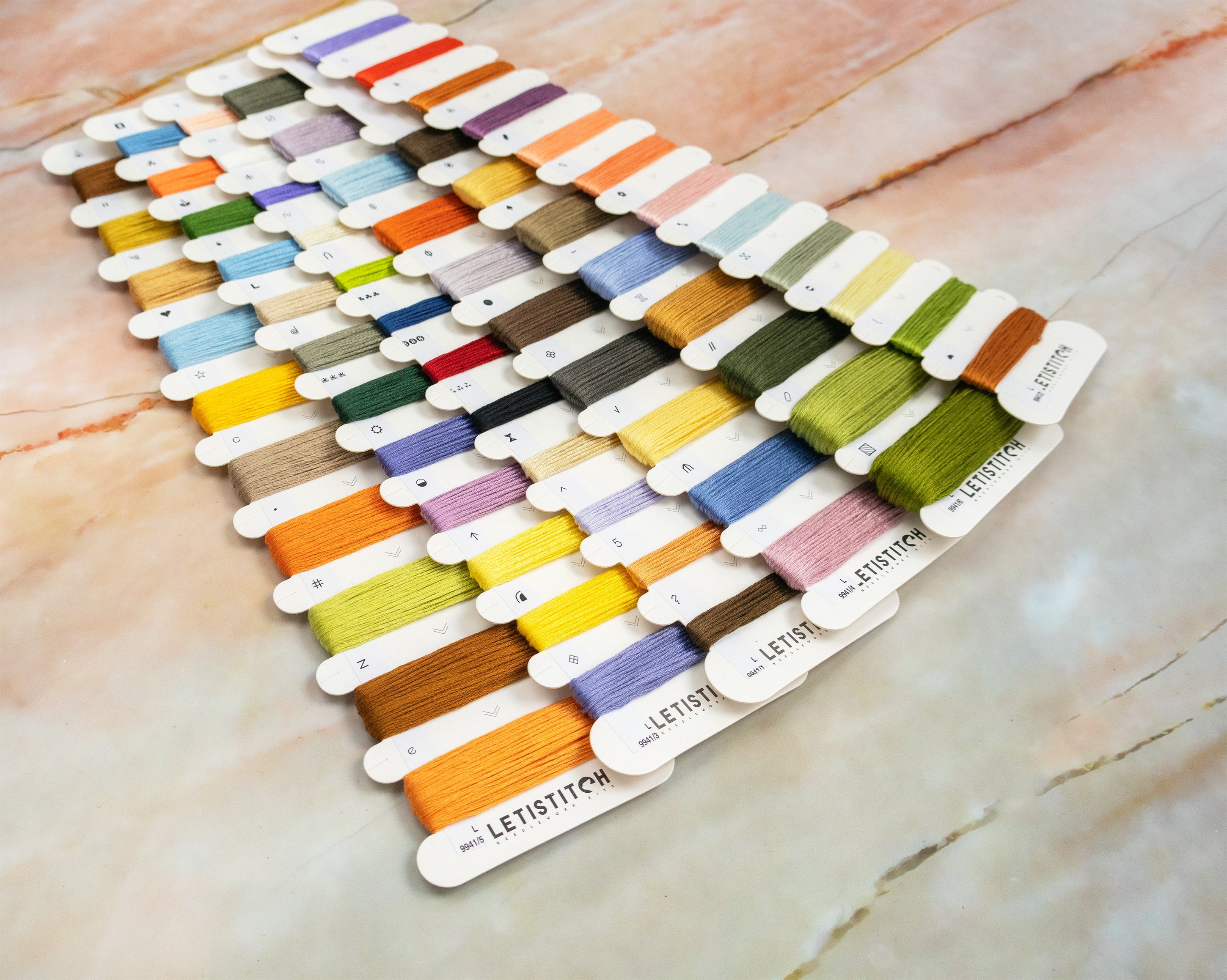 Color swatch card with embroidery threads on a marble surface