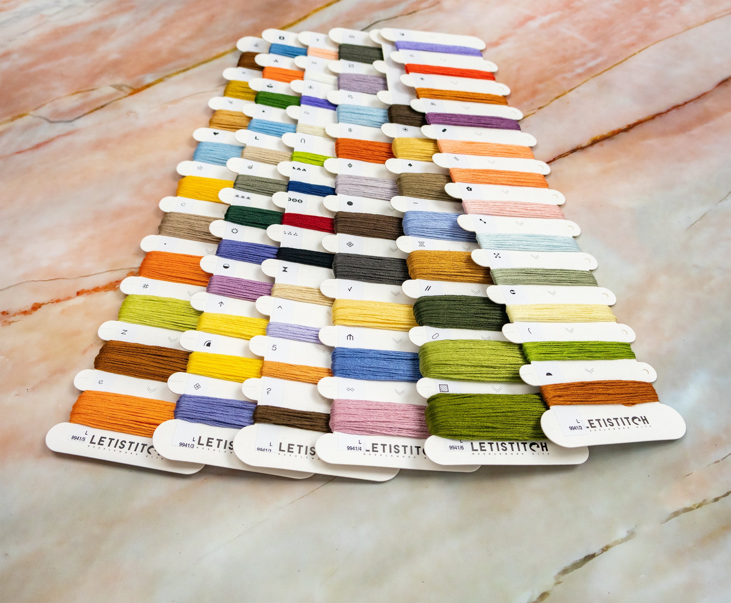 Color swatch card with various threads on a marble surface