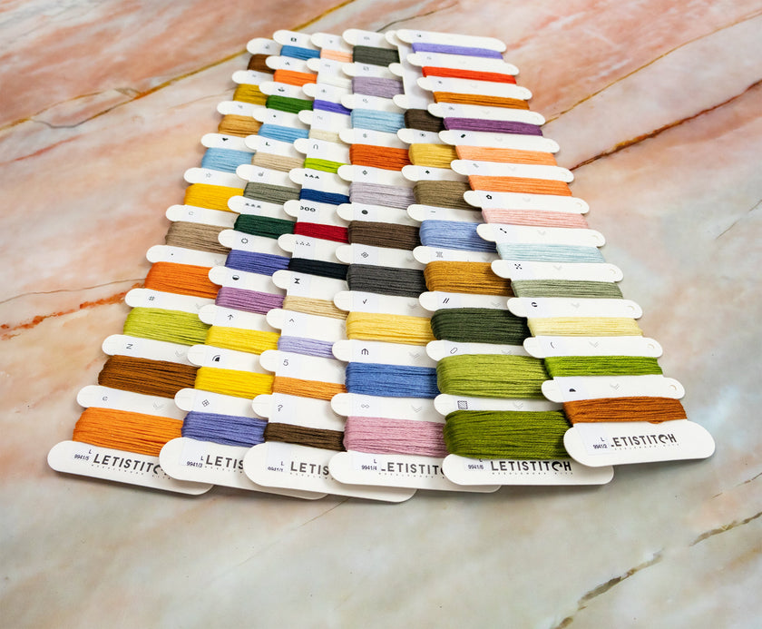 Color swatch card with various threads on a marble surface