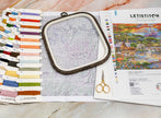 Embroidery kit with hoop, threads, and pattern on a marble surface
