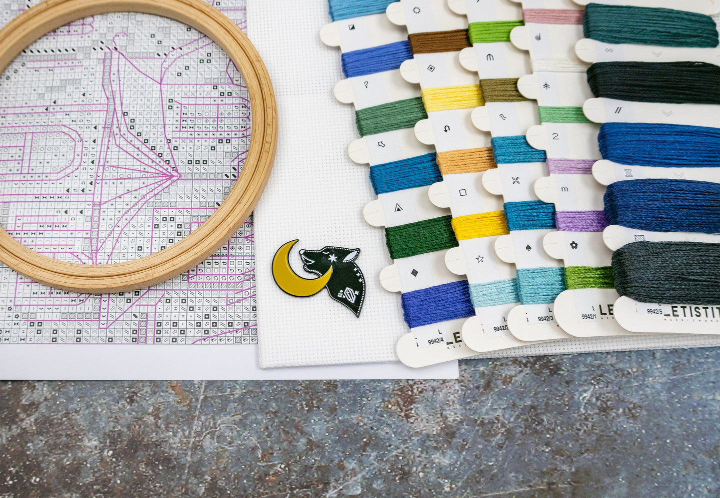Embroidery hoop and color swatch with embroidery threads on a textured surface