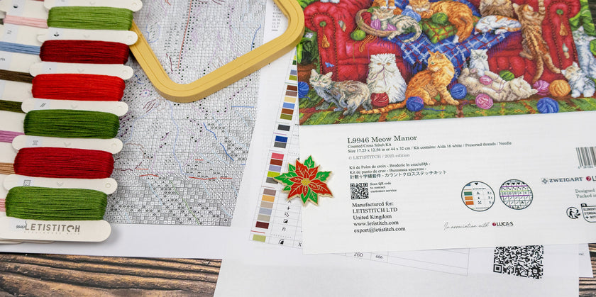 Embroidery kit with thread colors, pattern chart, and brand information on a wooden surface.