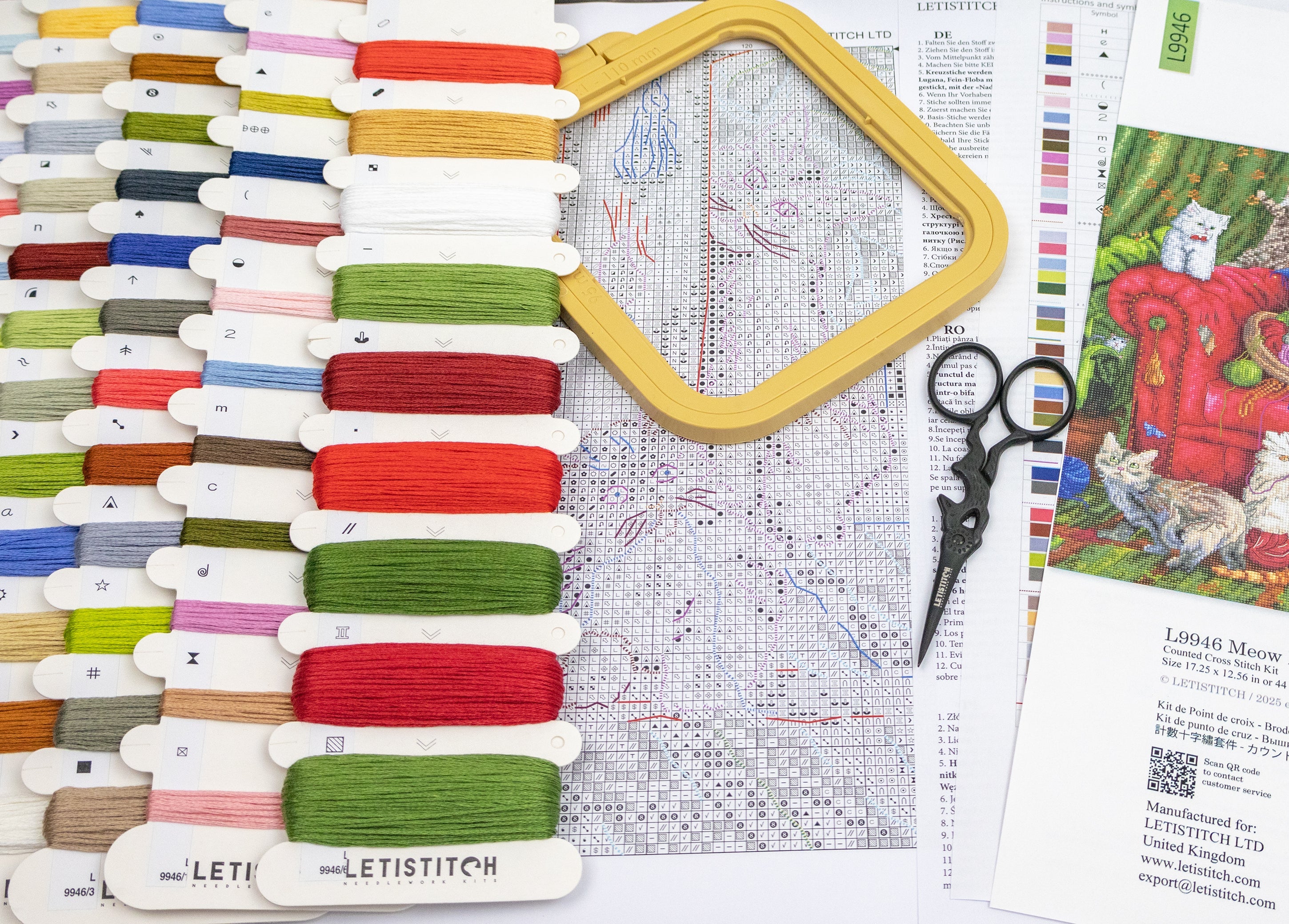 Embroidery hoop, threads, scissors, and cross-stitch pattern on a table.