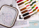 Embroidery hoop with colorful thread samples on a map background