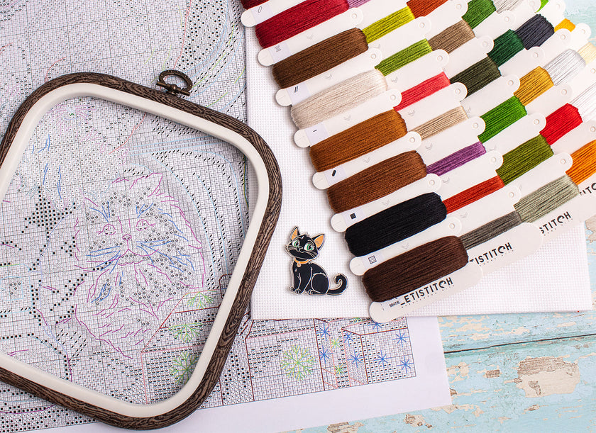 Embroidery hoop with colorful thread samples on a map background