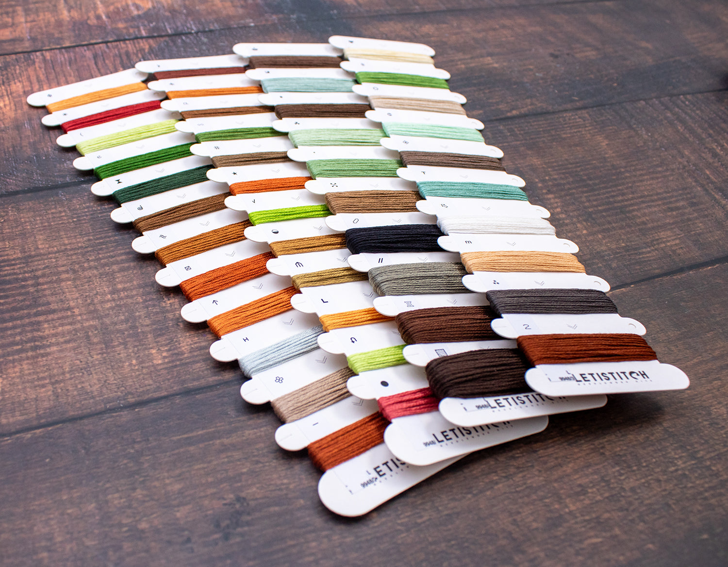 Set of colorful thread samples on a wooden surface