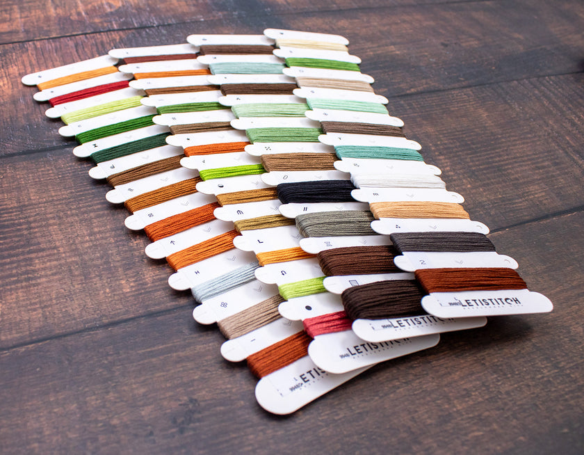 Set of colorful thread samples on a wooden surface