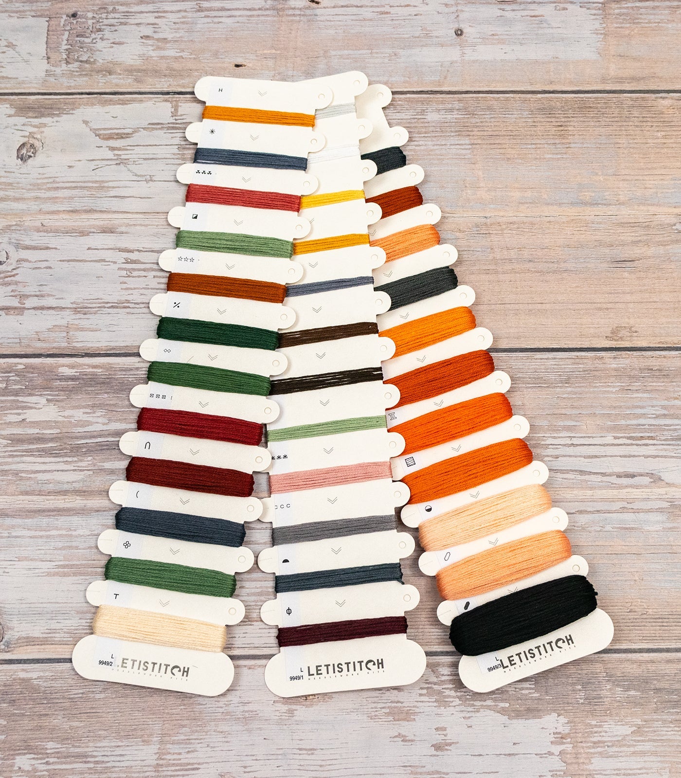 Color swatch chart with various yarn colors on a wooden surface