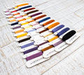 Set of embroidery floss colors on a wooden surface with 'LetiStitch' branding.