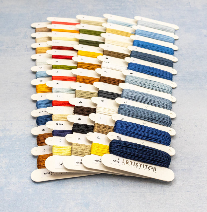 Set of embroidery threads on wooden sticks with 'Letistitch' branding on a light gray background