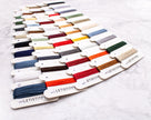 Color swatch card with various colored threads on a white background