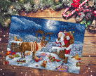 Decorative Christmas scene with Santa Claus, reindeer, and gifts on a wooden surface.
