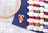 Embroidery hoop, colorful thread spools, and a candy cane ornament on a grid background