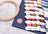 Embroidery hoop and thread spools on a grid surface with a brand mat.