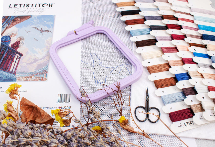 Embroidery hoop with threads and scissors on a table