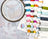 Embroidery hoop with partially completed design and spools of thread on a table.