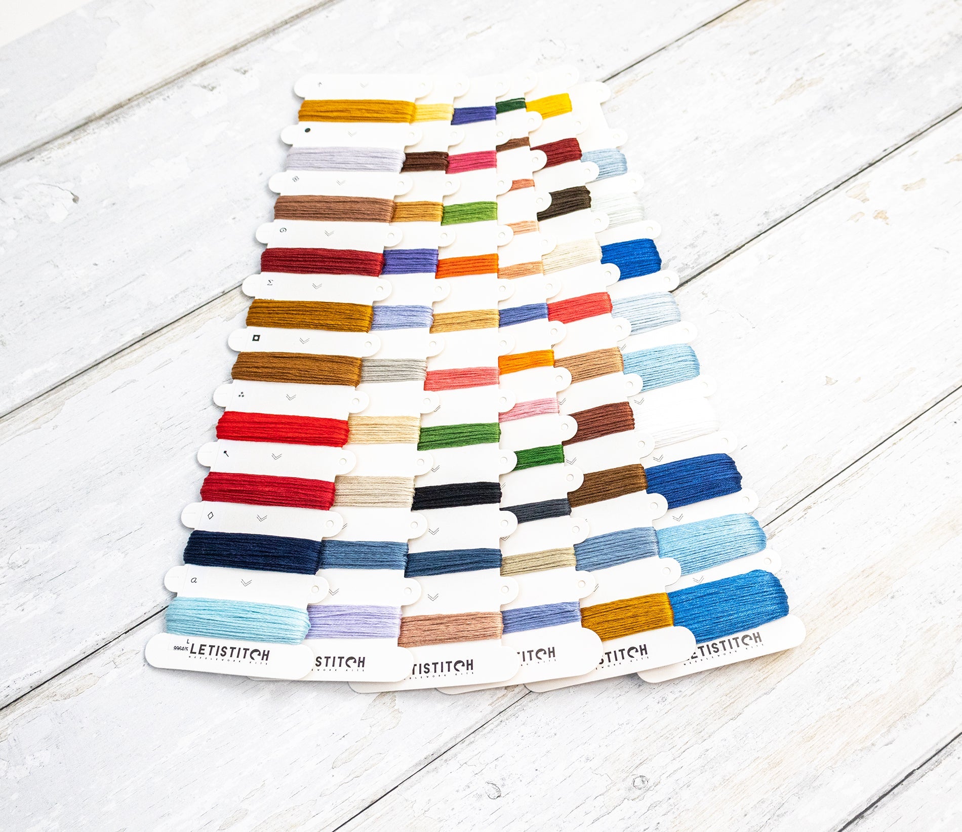 Color swatch card with embroidery floss on a wooden surface