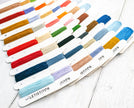 Set of embroidery floss colors on cards with 'Letistitch' branding on a white wooden surface.