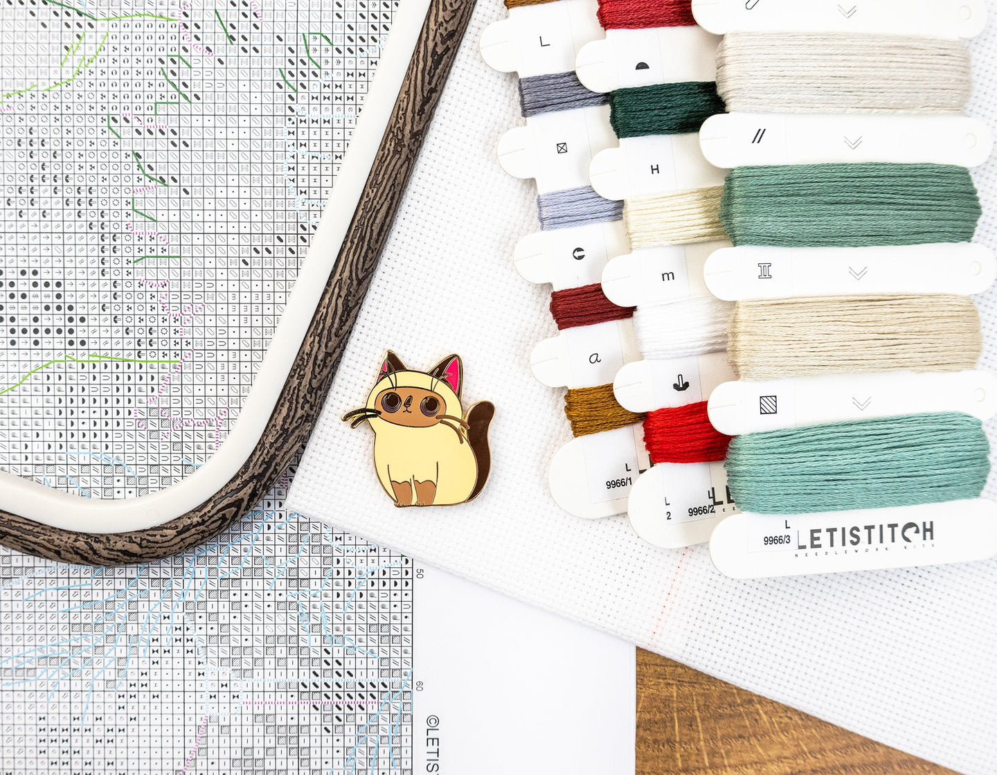 Collection of embroidery threads and a cross-stitch hoop on a wooden surface.