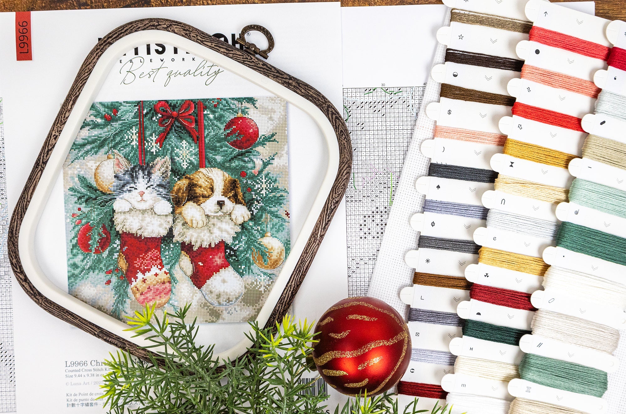 Cross-stitch kit with a Christmas-themed design, threads, and a ruler on a white background.