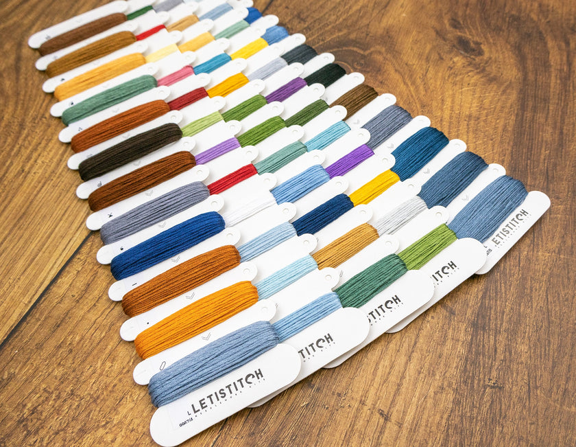 Set of embroidery floss colors on a wooden surface