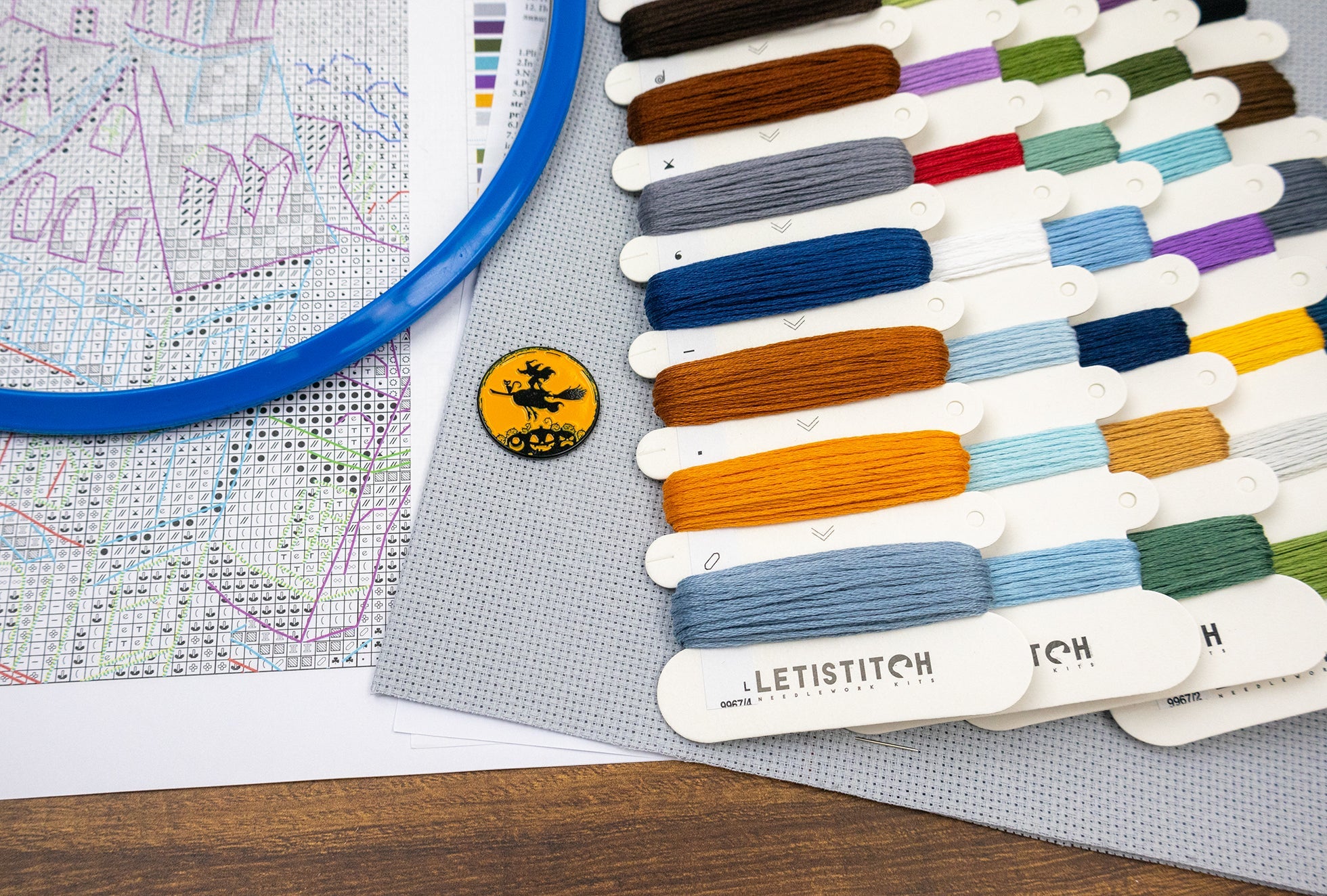 Color swatches from Letistitch with a map and badge on a wooden surface