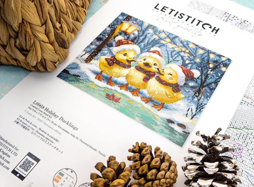 Cross-stitch kit with 'Letistitch' branding featuring three yellow ducks in winter attire on a snowy background.