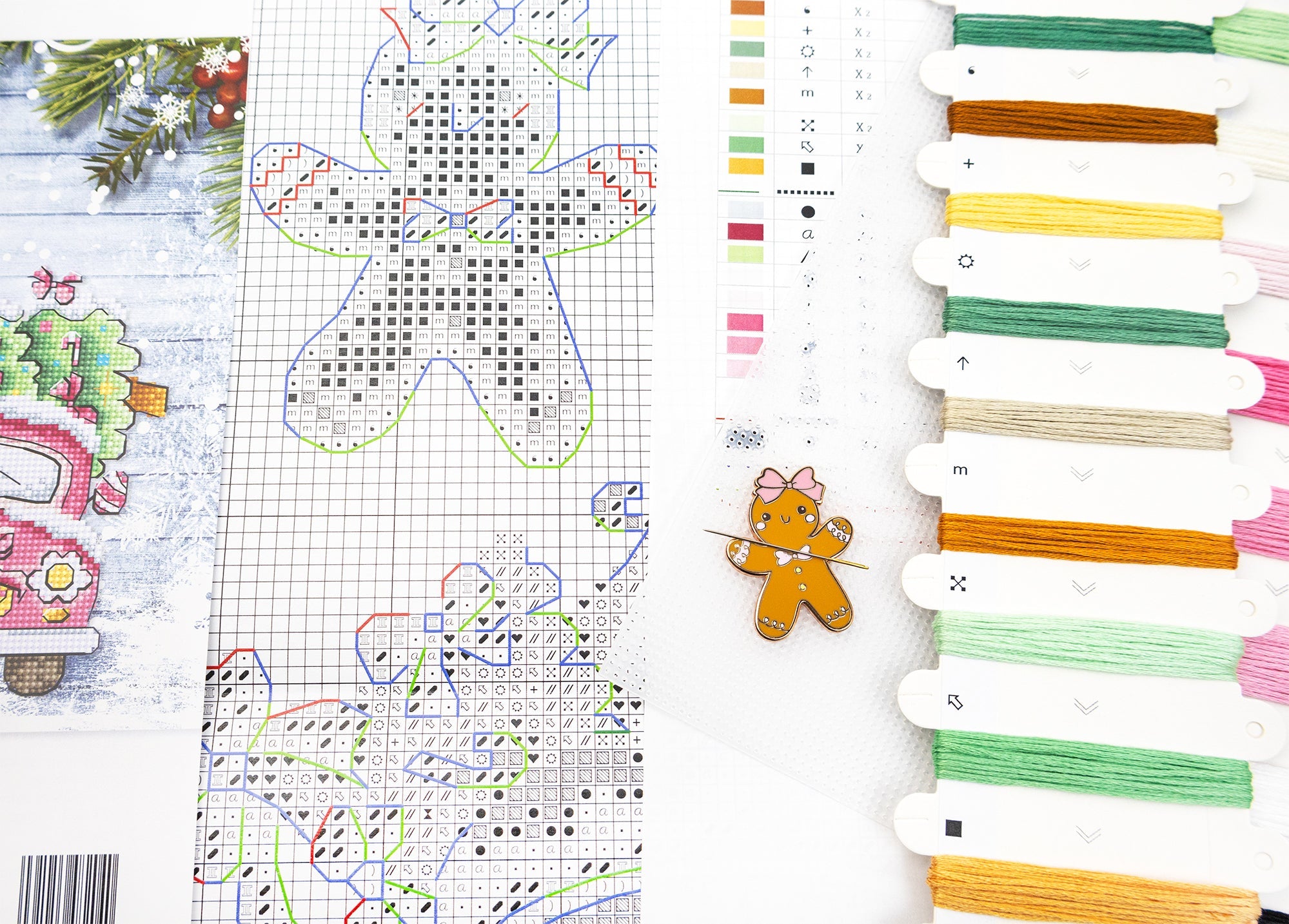 Cross-stitch pattern with gingerbread man design and colorful threads on a white background