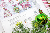Decorative Christmas ball on a sheet of paper with illustrations and text