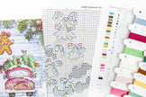 Cross-stitch pattern with Christmas-themed designs and embroidery threads.