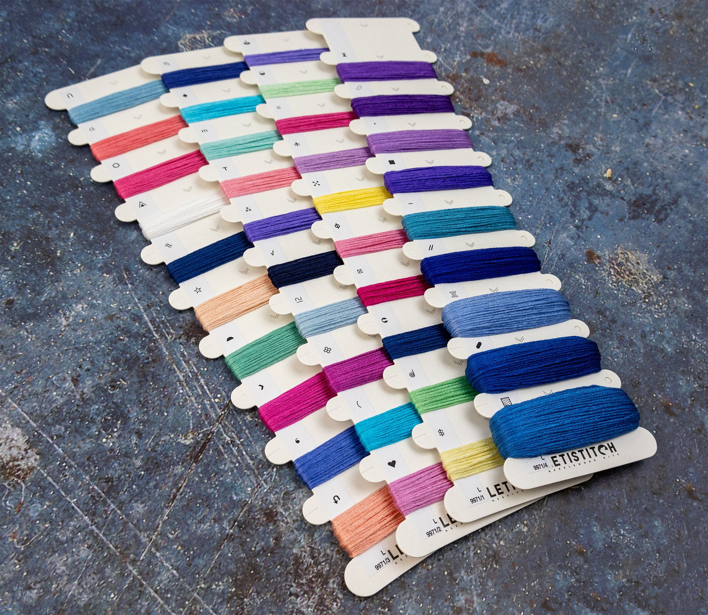 Color swatch card with various embroidery floss colors on a textured surface