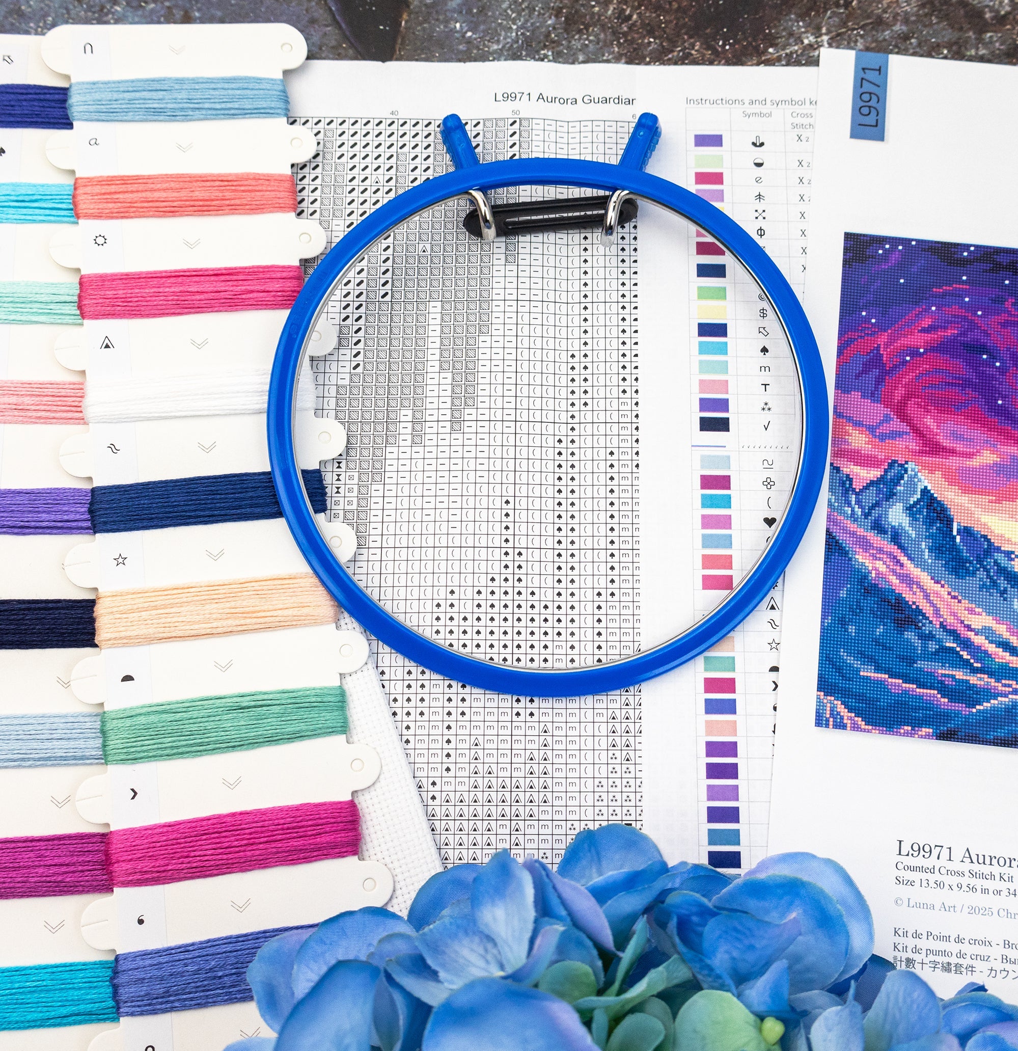 Embroidery hoop with cross-stitch pattern and fabric swatches on a table