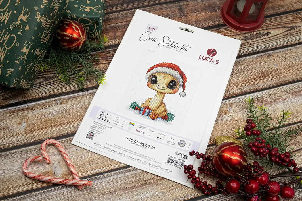 Cross-stitch kit for Luca's on a wooden surface with Christmas decorations