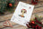 Cross-stitch kit for Luca's on a wooden surface with Christmas decorations