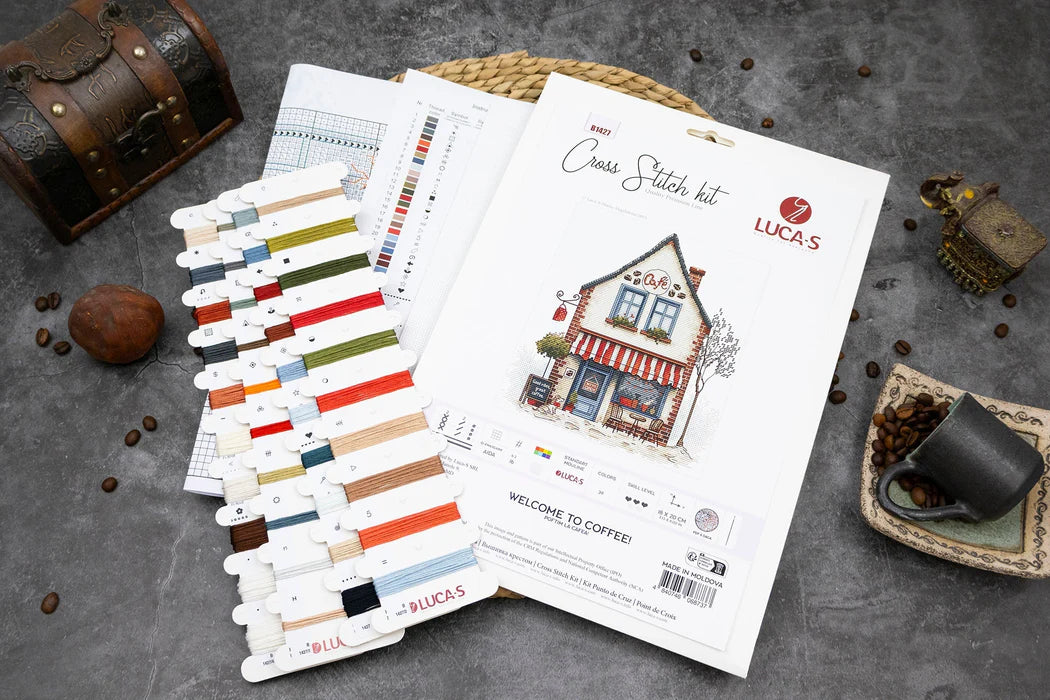 Cross stitch kit with color chart and packaging on a textured surface